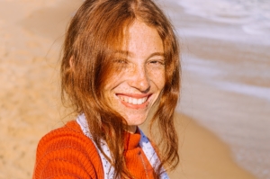 Lächelnde Dame am Strand, fröhliche Kundin